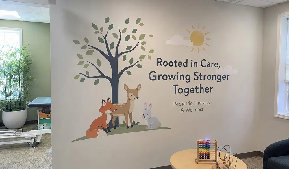 Printed tree, deer, fox and rabbit illustration on a wall.
